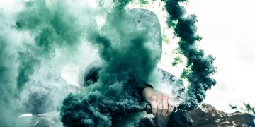 person holding gas grenade