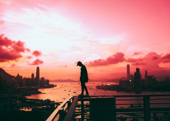 silhouette of person standing on railing