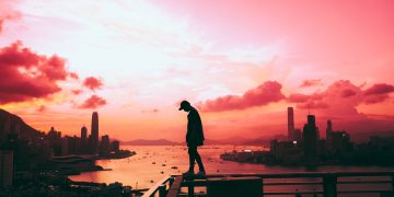 silhouette of person standing on railing