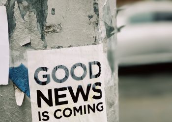 white Good News Is Coming paper on wall